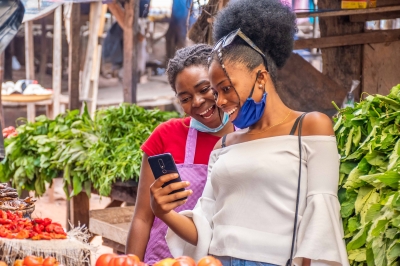 Two-women-viewing-content-phone-local-african-market.jpg